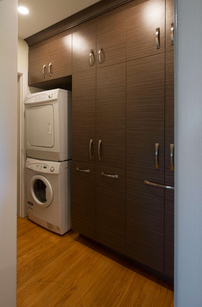 Custom cabinetry around a washer-dryer stack.