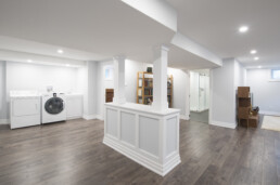A beautiful finished basement renovation, complete with laundry, bathroom, storage, and an entertainment space.
