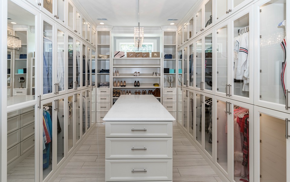 A beautiful walk-in closet with central island and glass doors for all items.