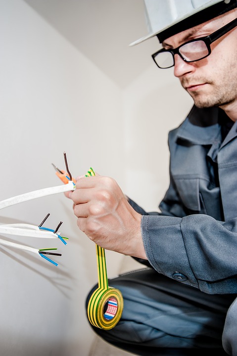 An electrician working on wiring in a home.