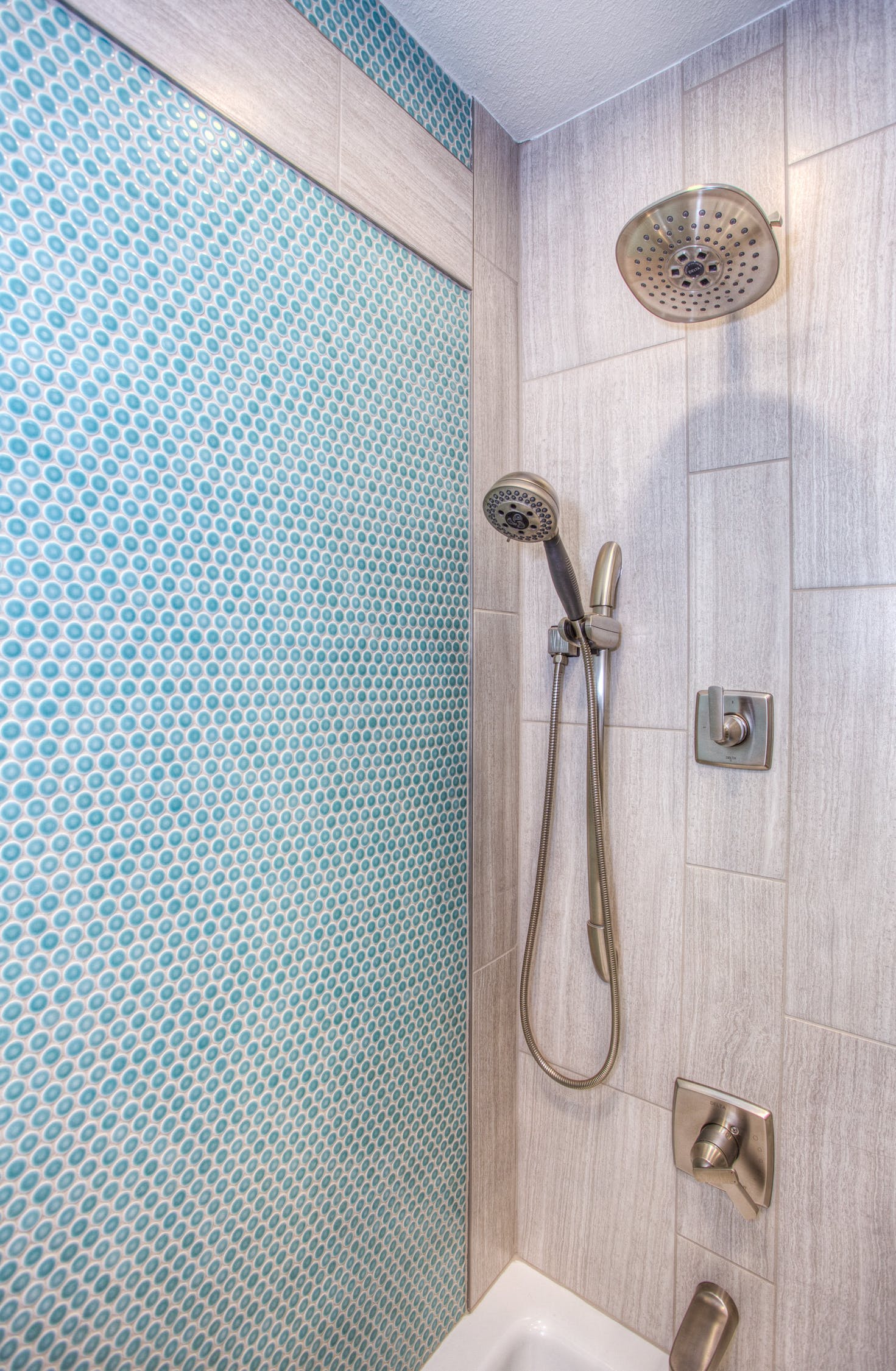renovated shower with large and small tiles