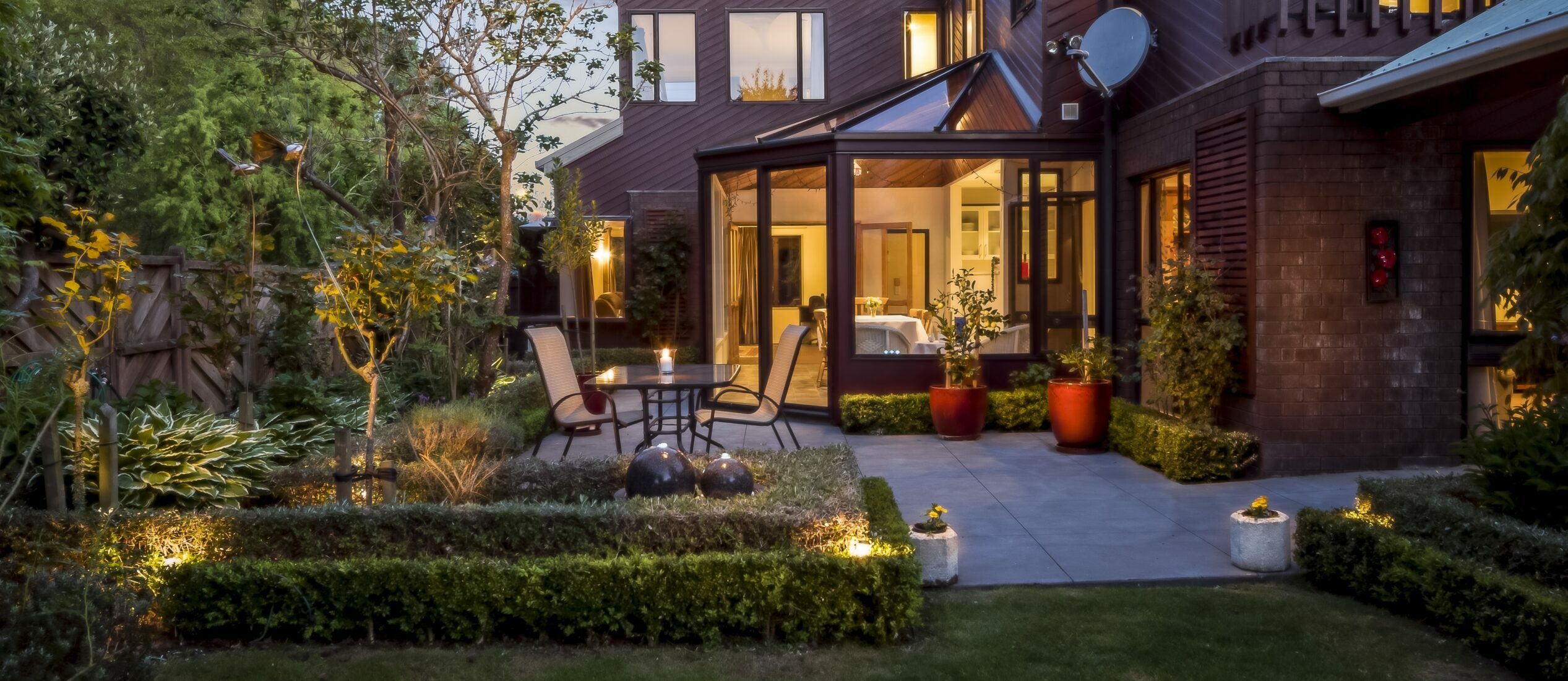 A big private house with a garden under the cloudy sky at night